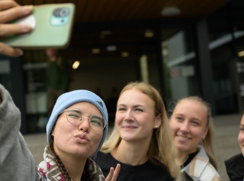 Studierende der EH mit Smartphone machen Selfie